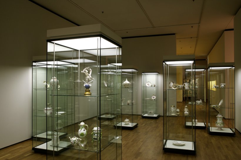 Ausstellungsansicht: Mehrere hohe Vitrinen im Raum verteilt, enthalten Porzellan