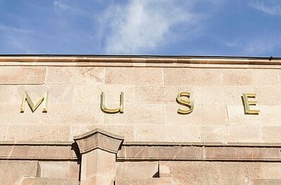 Detailaufnahme der goldenen Buchstaben, die den Museumsnamen am Gebäude bilden