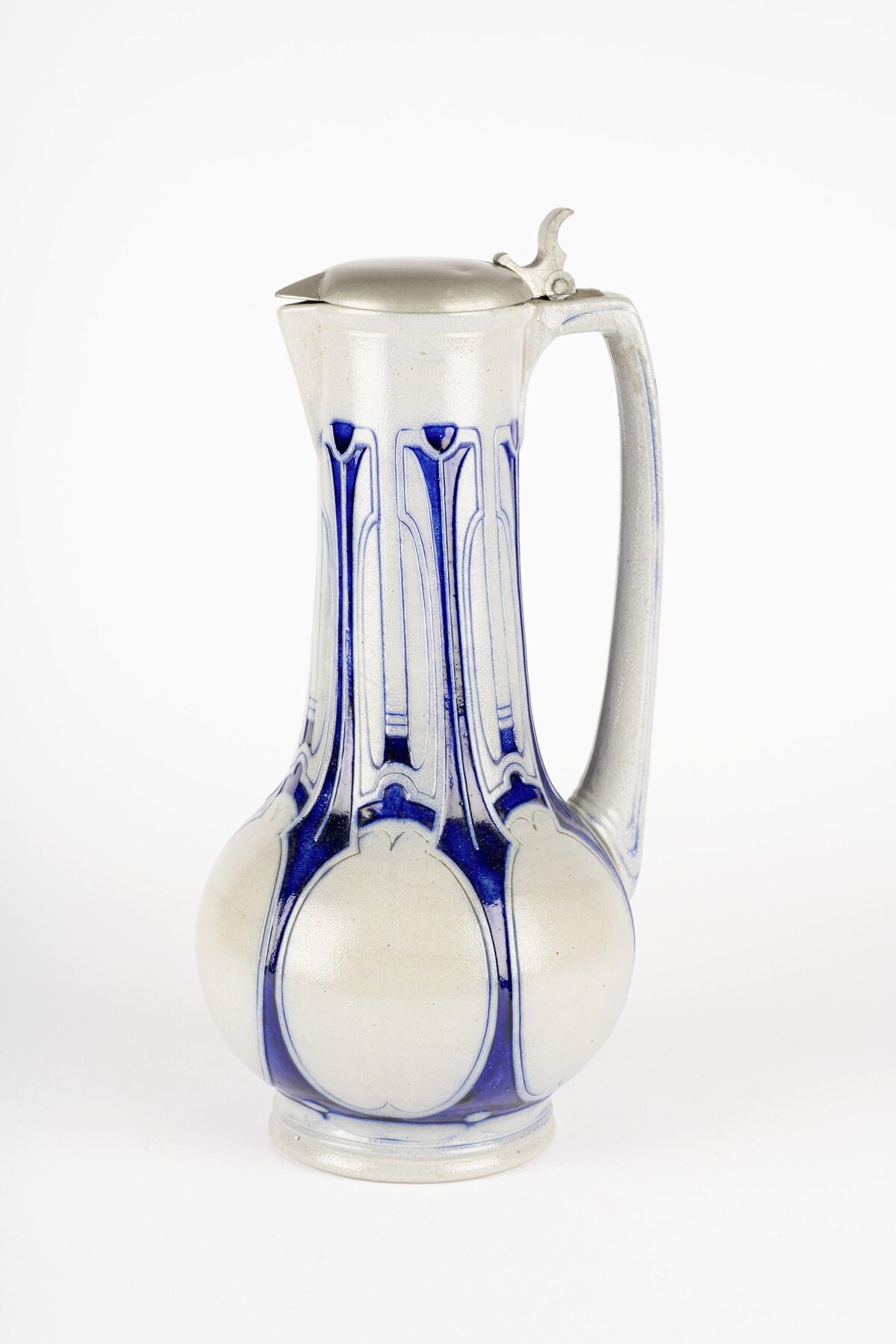 Kanne; Entwerfer: Peter Behrens; Ausführung: Simon Peter Gerz I, Steinzeug- und Majolikafabrik um 1903, Höhr; Steinzeug, salzglasiert, Zinnmontierung; Schenkung Sammlung Pese, Nürnberg, 2020; Creditline: GRASSI MAK, Leipzig. Aufnahme: F. Bielmeier