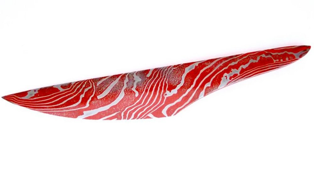 Rot-Silbernes Objekt welches einem Messer aus Damaskus Stahl ähnelt