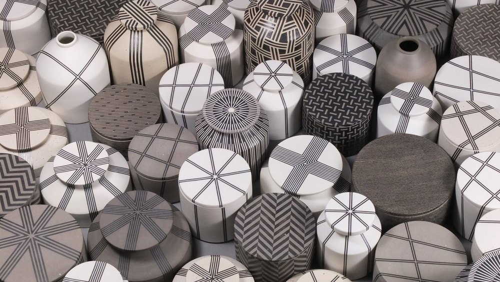 Viele verschiedene im weiß-grau Ton gefärbte Keramik Vasen und Behälter